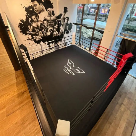 SportCom Boxring-Individualisierung: schwarzer Ringboden mit weißem Logo und roter Ecke in einem Club