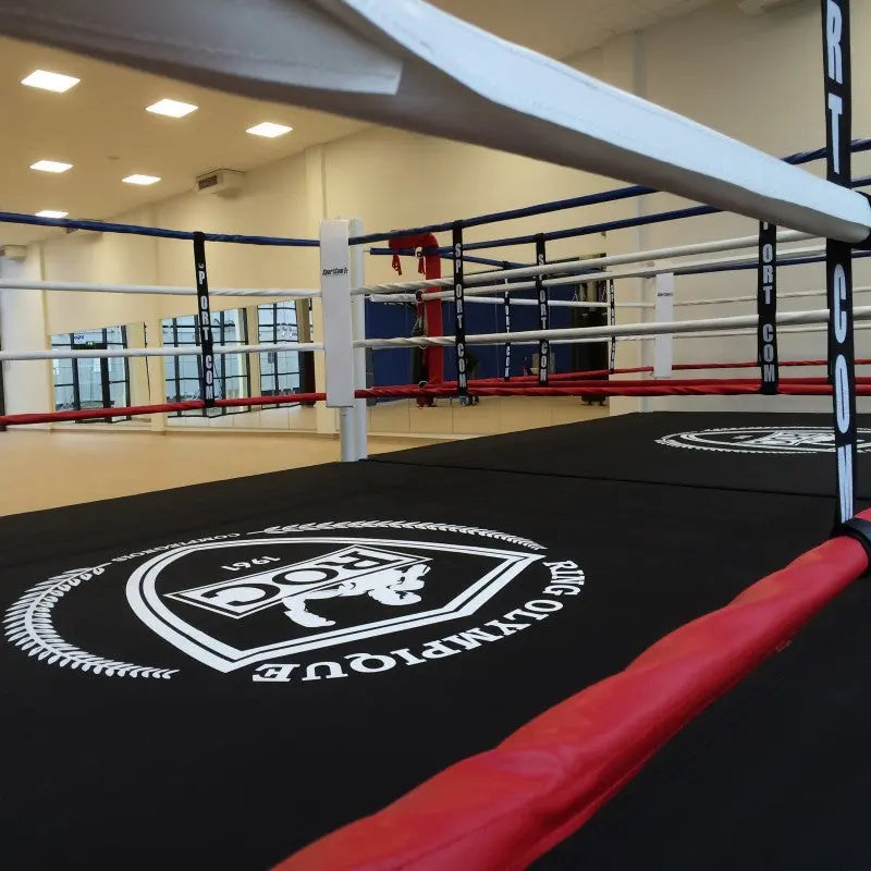 SportCom Boxring-Individualisierung: Detail des Ringbodens mit rundem Logo und roter Seilummantelung