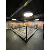 SportCom Boxring-Individualisierung: Bodenring mit gelben Eckpolstern in einer Halle mit Deckenleuchte