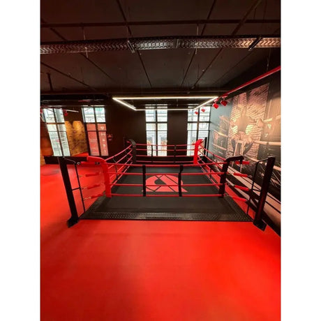 SportCom Boxring-Individualisierung: Bodenring auf rotem Hallenboden mit Lichtrahmen und hohen Fenstern