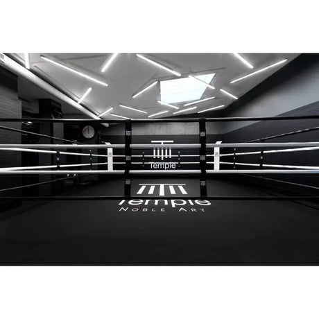 SportCom Boxring-Individualisierung: schwarzer Ring mit weißem Schriftzug unter einer Lichtinstallation