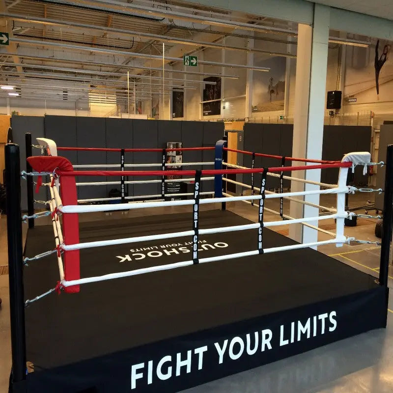 SportCom Boxring-Individualisierung: Ring mit bedruckter Schürze und roter Ecke in einer hellen Trainingshalle