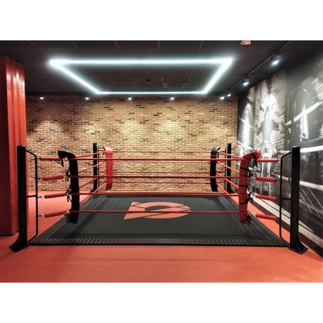 SportCom Boxring-Individualisierung: roter Ringboden mit Logo, Lichtrahmen und Backsteinwand im Studio