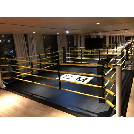 SportCom Boxring-Individualisierung: Ring mit gelben Seilen und weißem Logo-Druck in einem Fitnessstudio