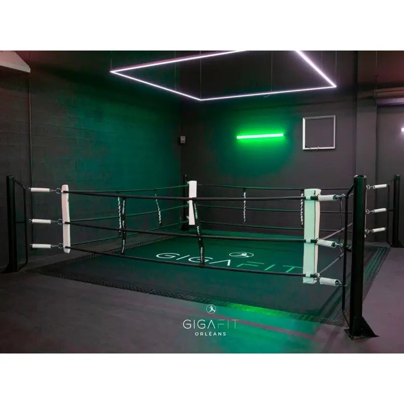 SportCom Boxring-Individualisierung: schwarzer Ring mit grünem Neonlicht und bedrucktem Boden im Studio