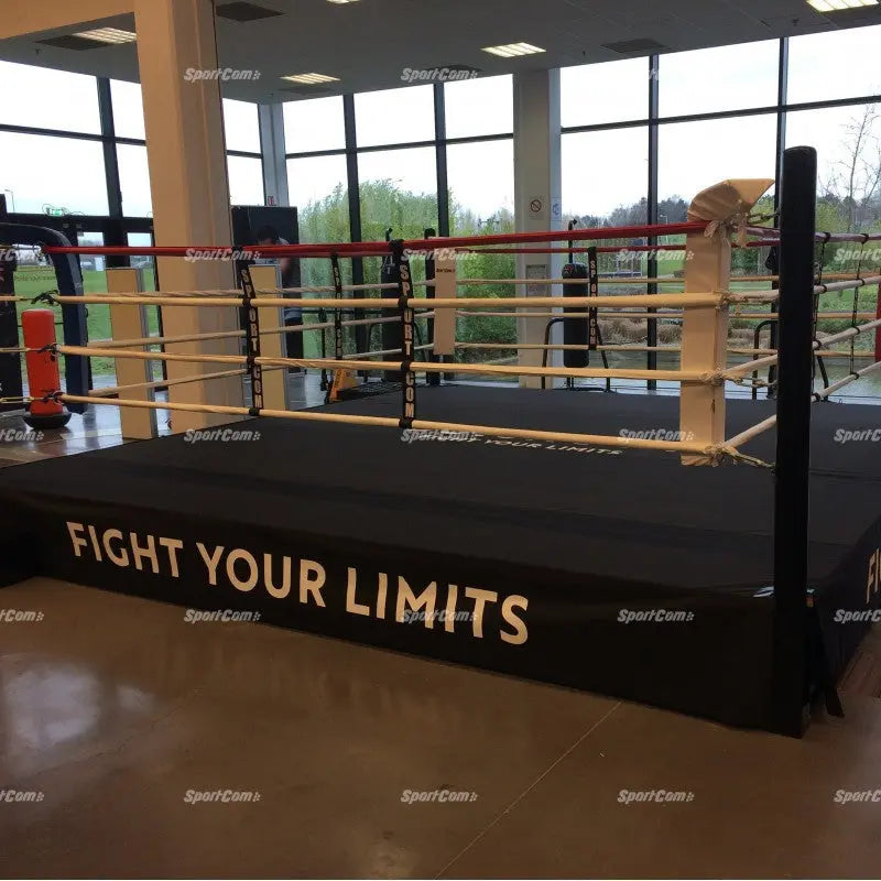 SportCom Boxring-Schürze aus Cordura mit Aufdruck Fight Your Limits an einem Ring vor großer Fensterfront