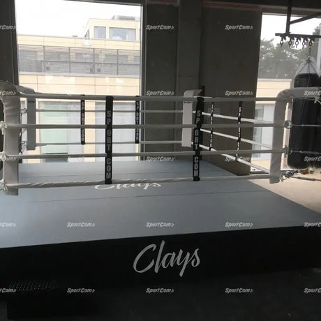 Schwarze SportCom Boxring-Schürze aus Cordura mit weißem Schriftzug an einem Ring im Studio