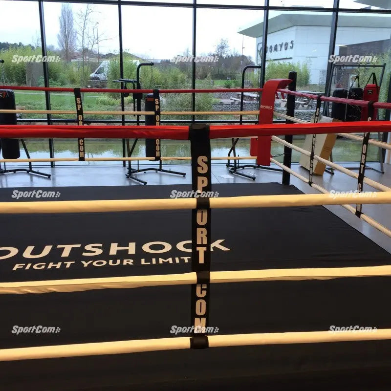 SportCom Boxring-Seiltrenner 8er-Set an einem Ring mit roten und beigen Seilen und bedrucktem Boden