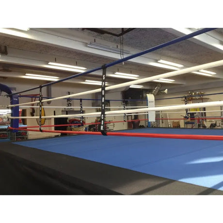 SportCom Boxring-Seiltrenner 8er-Set an einem Ring mit blauem Boden und hellen Seilen in einer Halle