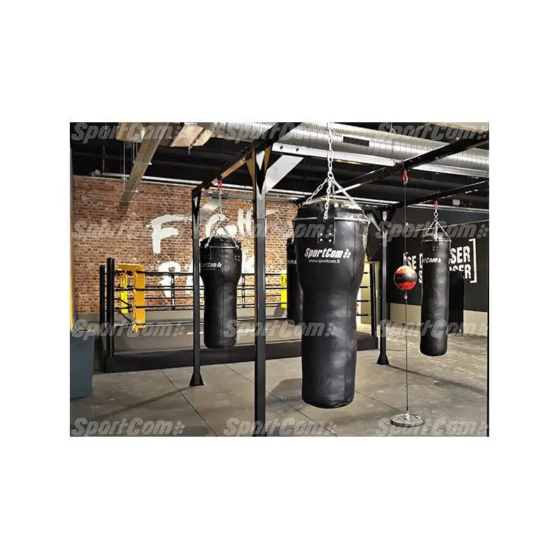 SportCom Echtleder-Uppercut-Sandsack 1,20 m in einem Boxstudio mit Backsteinwand und Ring