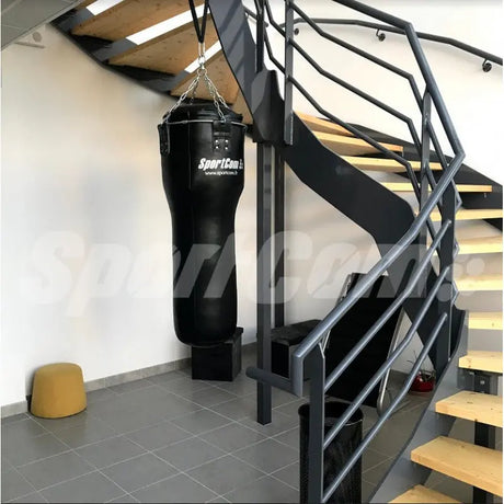 SportCom Echtleder-Uppercut-Sandsack 1,20 m in Schwarz, aufgehängt neben einer Treppe