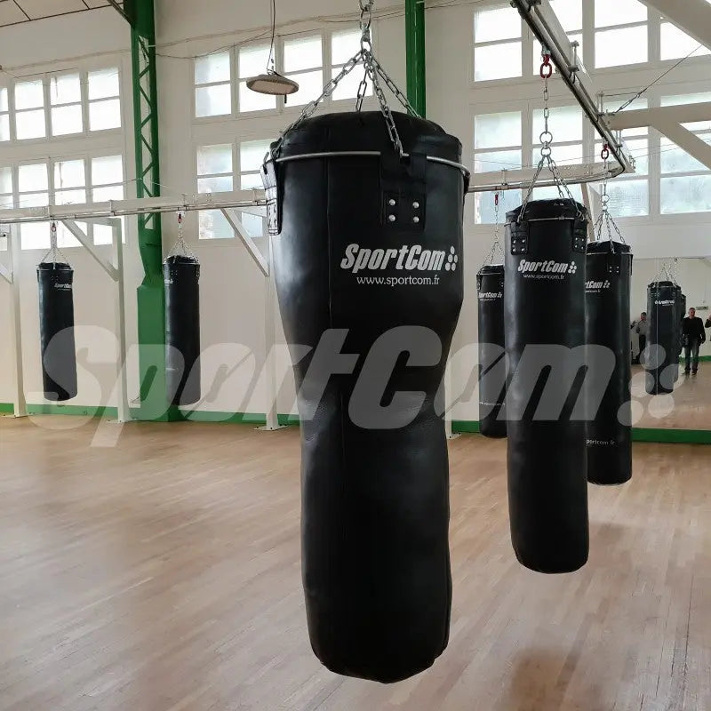 SportCom Echtleder-Uppercut-Sandsack 1,20 m: mehrere Sandsäcke in einem hellen Studio mit Holzboden
