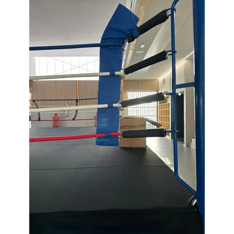 SportCom Eckpolster-Set für Boxringe mit 4 Seilen, blaues Eckpolster an blauem Pfosten mit schwarzen Seilen