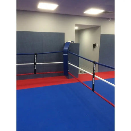 SportCom Eckpolster-Set für Boxringe mit 4 Seilen, blaues Eckpolster an einem Studio-Boxring mit blauem Boden