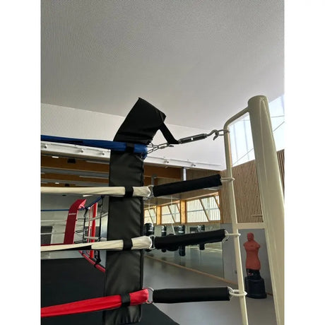 SportCom Eckpolster-Set für Boxringe mit 4 Seilen, schwarzes Eckpolster an Ring mit gepolsterten Seilen in einer Halle