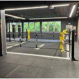 SportCom Ecofix Bodenmontage-Boxring mit Aluminiumrand, in einem Gym mit Fensterfront und gelben Polstern