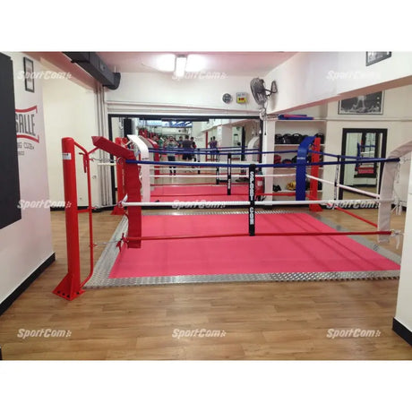 SportCom Ecofix Bodenmontage-Boxring mit Aluminiumrand, in einem Gym mit rotem Boden und Spiegelwand