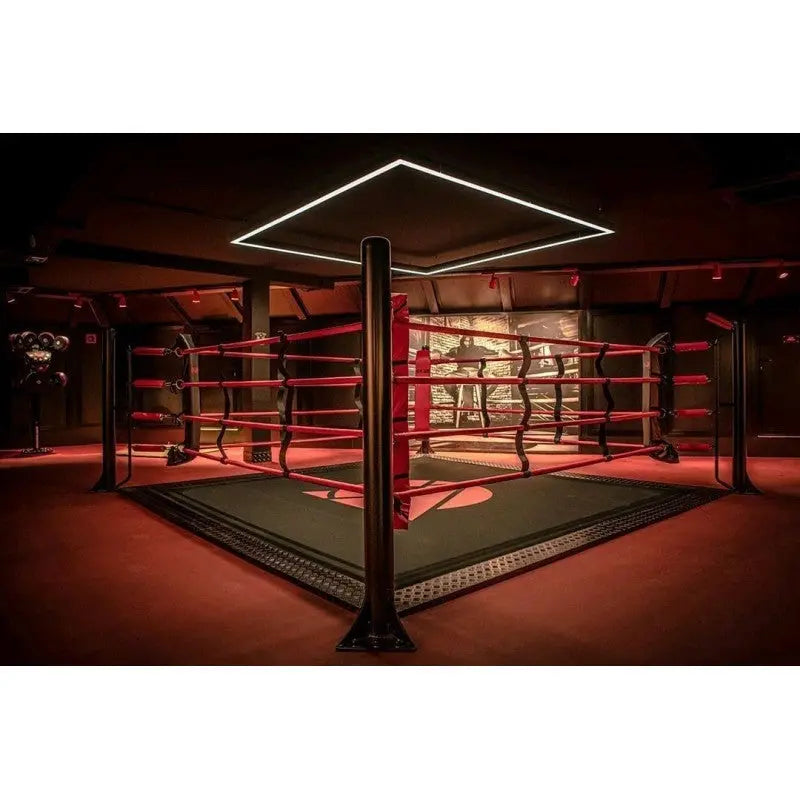 SportCom Ecofix Bodenmontage-Boxring mit Aluminiumrand, in einem rot beleuchteten Gym mit Lichtrahmen