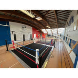SportCom Ecofix Bodenmontage-Boxring mit Aluminiumrand, in einer Halle mit Holzdecke, rote und blaue Seile