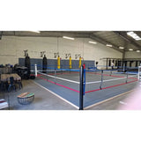 SportCom Ecofix Bodenmontage-Boxring in einer Trainingshalle, weite Ansicht mit blauen Pfosten