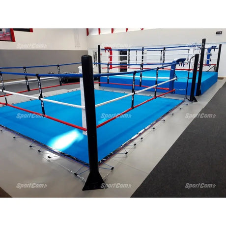 SportCom Ecofix Bodenmontage-Boxring mit Spannseilen, mit blauem Boden in einer Halle, Eckpfosten vorne