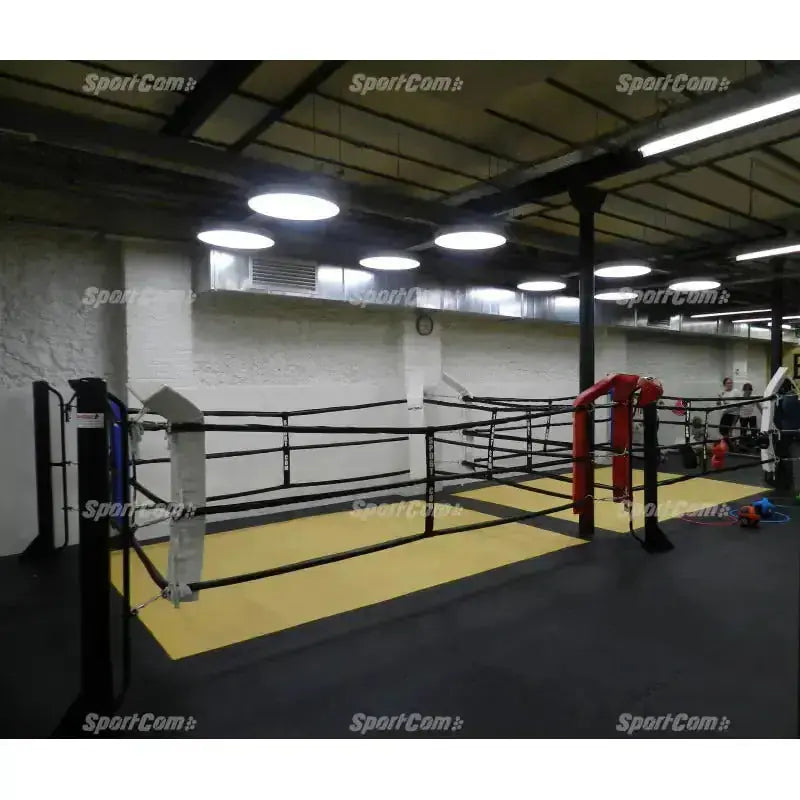 SportCom Ecofix Boxring bodenmontiert auf gelber Mattenfläche in einem Boxstudio mit Hängelampen