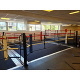 SportCom Ecofix Doppel-Boxring mit Aluminiumrand, in einer Trainingshalle mit gelben und schwarzen Pfosten