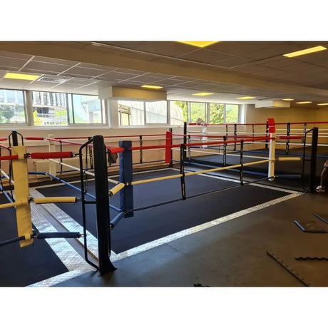 SportCom Ecofix Doppel-Boxring mit Aluminiumrand, in einer Trainingshalle mit gelben und schwarzen Pfosten