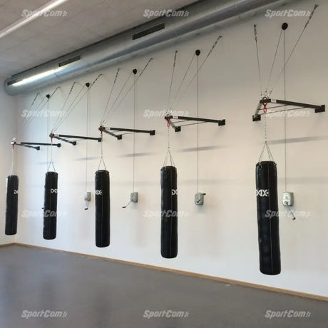 SportCom Faltbare Sandsackhalterung mit Handwinde: Reihe montierter Halterungen mit Boxsäcken in einer Trainingshalle