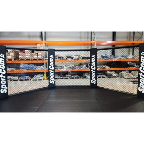 SportCom Faltbarer MMA-Käfig, vor Lagerregalen mit Logo-Polstern