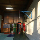 SportCom Feste Sandsackhalterung mit Stabilisierung in Blau, Sandsack und Birnenball in einer Trainingshalle