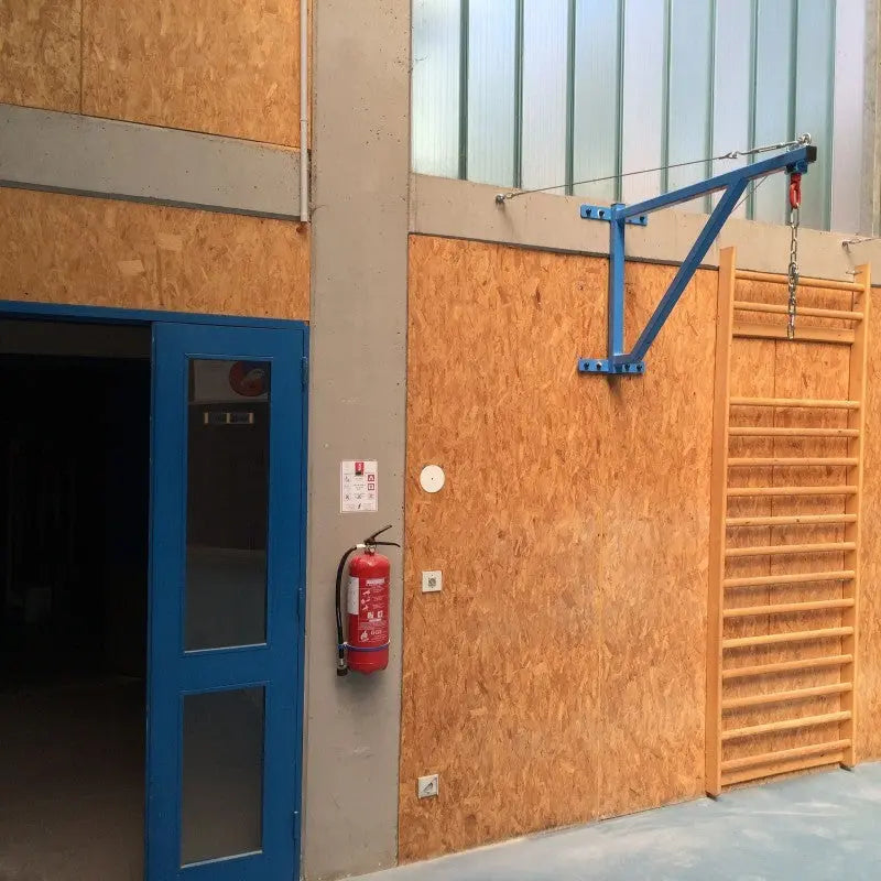 SportCom Feste Sandsackhalterung mit Stabilisierung in Blau an Holzwand einer Sporthalle ohne Sandsack