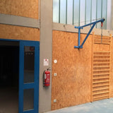SportCom Feste Sandsackhalterung mit Stabilisierung in Blau an Holzwand einer Sporthalle ohne Sandsack