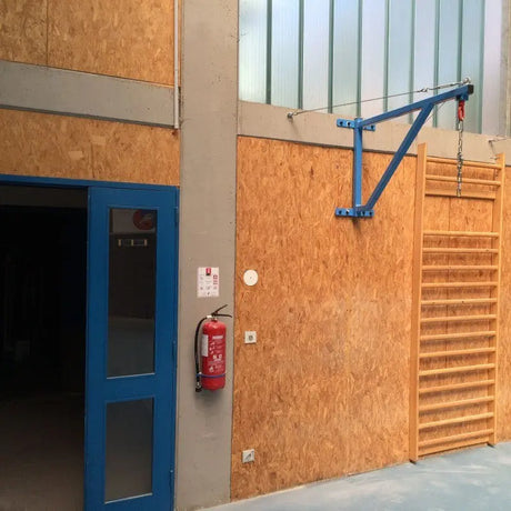 SportCom Feste Sandsackhalterung mit Stabilisierung in Blau an Holzwand einer Sporthalle ohne Sandsack