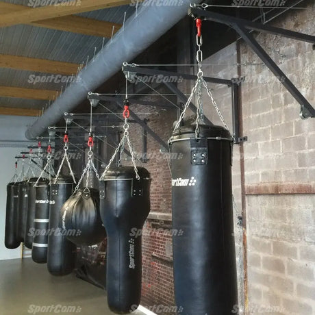 SportCom Feste Sandsackhalterung mit Stabilisierung in Reihe an Ziegelwand, viele Sandsäcke im Boxstudio