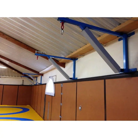 SportCom Feste Sandsackhalterung mit Stabilisierung, blaue Ausleger mit Streben unter der Hallendecke