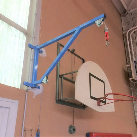 SportCom Feste Sandsackhalterung mit Umlenkrolle, blauer Wandarm neben einem Basketballkorb