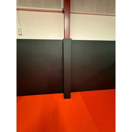 SportCom Flexi-Post Säulenpolster von Dollamur in Schwarz an einer Säule über rotem Mattenboden