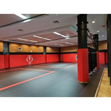 SportCom Flexi-Post Säulenpolster von Dollamur in Rot an Säulen eines Kampfsportstudios mit Wandpolstern