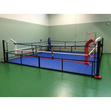 SportCom Flexi-Roll Mattenfläche für Boxringe in Blau im Podestring einer Halle mit grünem Boden
