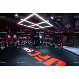 SportCom Flexi-Roll Mattenfläche für MMA-Käfige, verlegt in einem beleuchteten Gym mit rotem Logo auf der Fläche