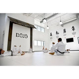 SportCom Flexi-Roll Ringermatte von Dollamur, weiße Fläche in einem Dojo, Personen im Kampfanzug