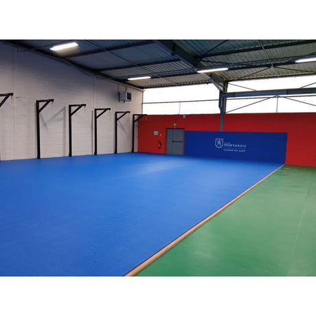 SportCom Flexi-Roll Ringermatte von Dollamur, blaue Fläche mit grünem Rand in einer Sporthalle