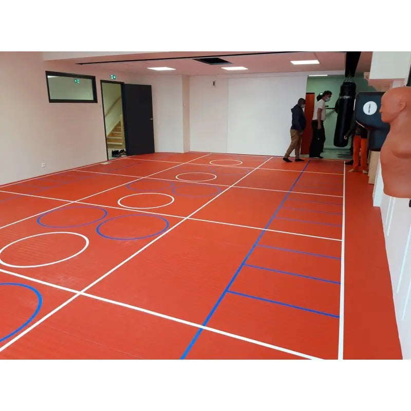 SportCom Flexi-Roll Ringermatte von Dollamur, rote Fläche mit Spielfeldlinien in einer Halle