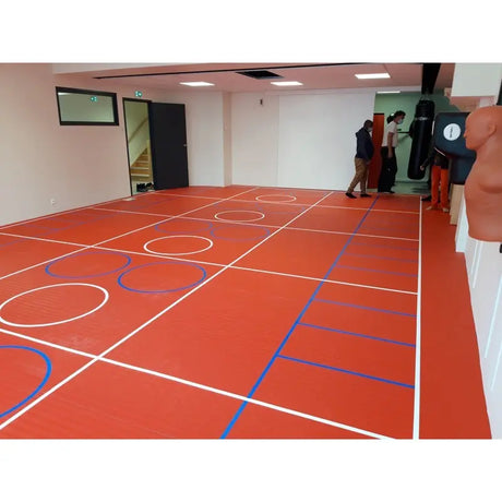 SportCom Flexi-Roll Ringermatte von Dollamur, rote Fläche mit Spielfeldlinien in einer Halle