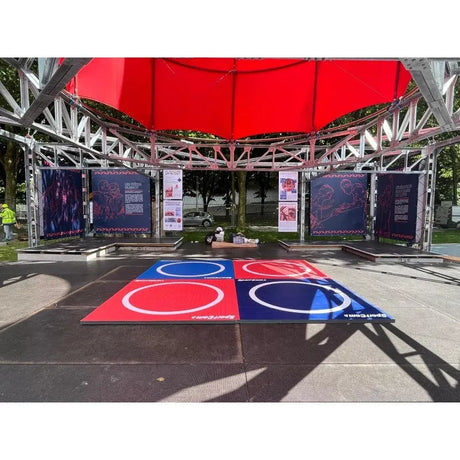 SportCom Flexi-Roll Wrestling Studio-Matte in Rot und Blau unter einem Zeltdach im Freien
