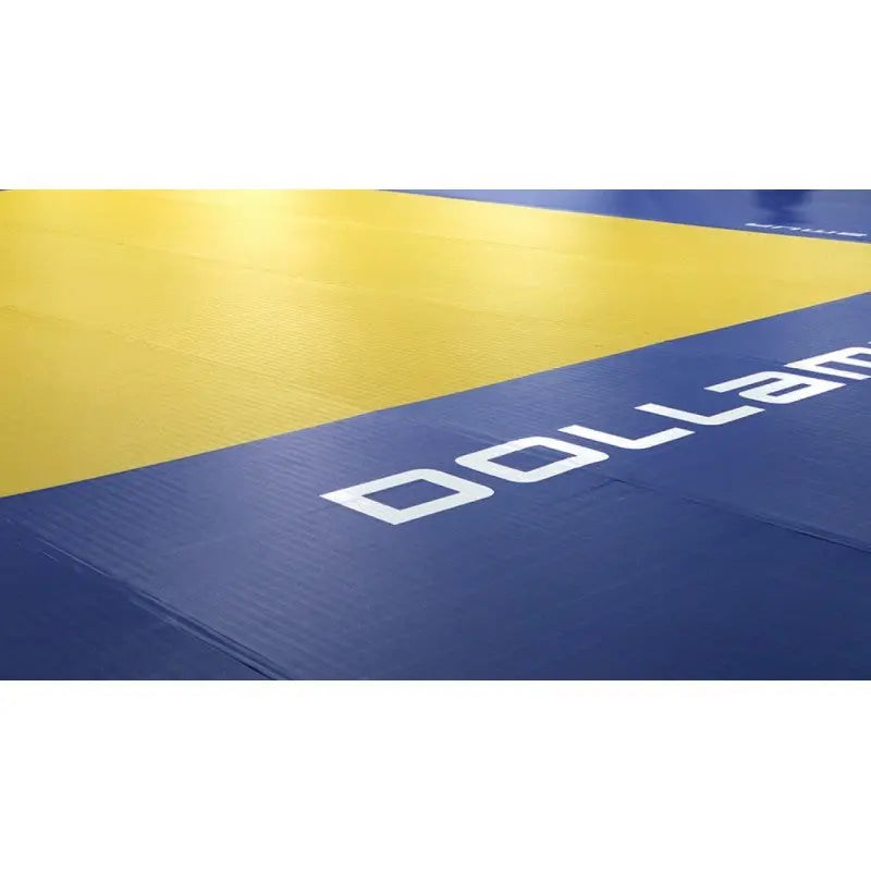 SportCom Flexi-Wall Wandschutz von Dollamur in Blau mit Schriftzug, Detail neben gelbem Boden