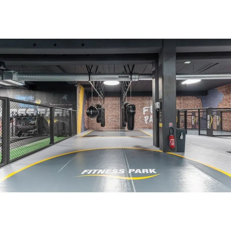 SportCom Flexi-Wall Wandschutz von Dollamur in Grau in einem Gym mit Käfig und Bodenmarkierung