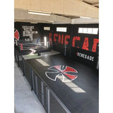 SportCom Flexi-Wall Wandschutz von Dollamur in Schwarz an der Wand eines Kampfsportstudios mit Logo