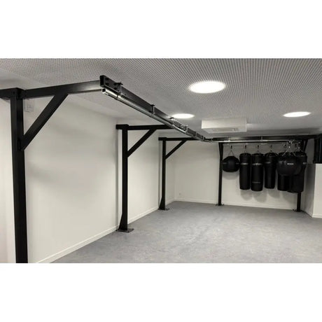 SportCom Förderschiene mit Rahmen für Sandsäcke, Blick entlang der Wand mit Sandsäcken hinten